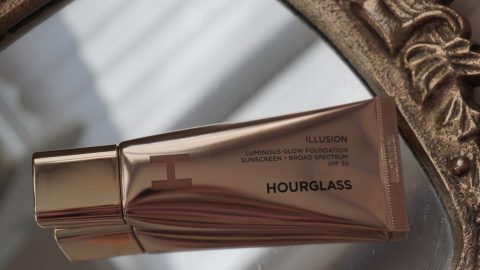 Hourglass Illusion Luminous Glow Foundation SPF 30 gold tube packaging in flat lay, highlighting luxury design and SPF foundation for spring makeup
